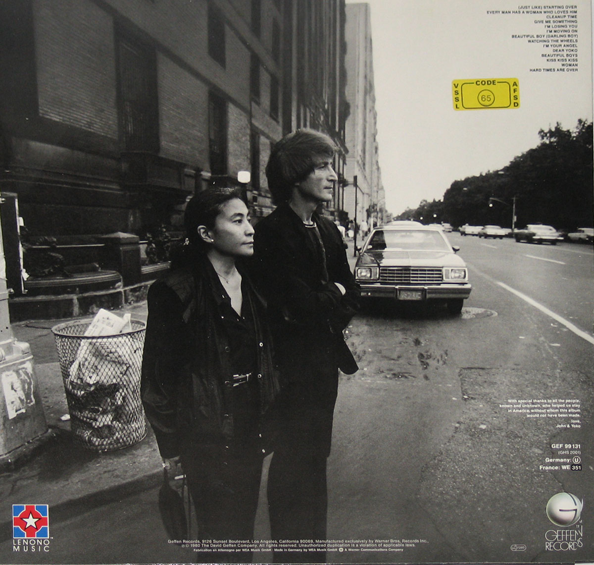 Photo of Yoko Ono and John Lennon standing in front of a trashcan and on the street